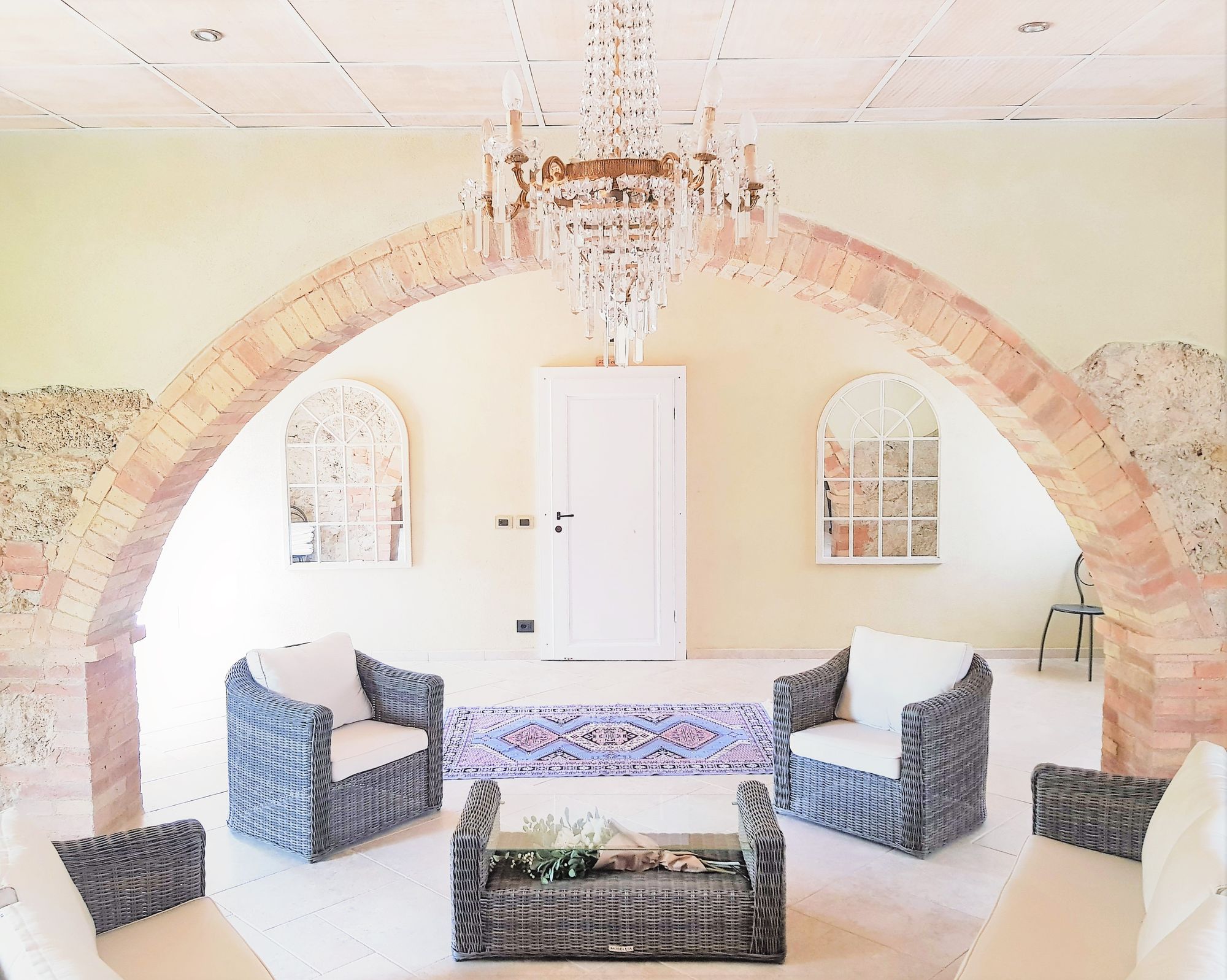 Salone di Villa Le Querce allestito con tavoli rotondi e lampadari per 120 invitati